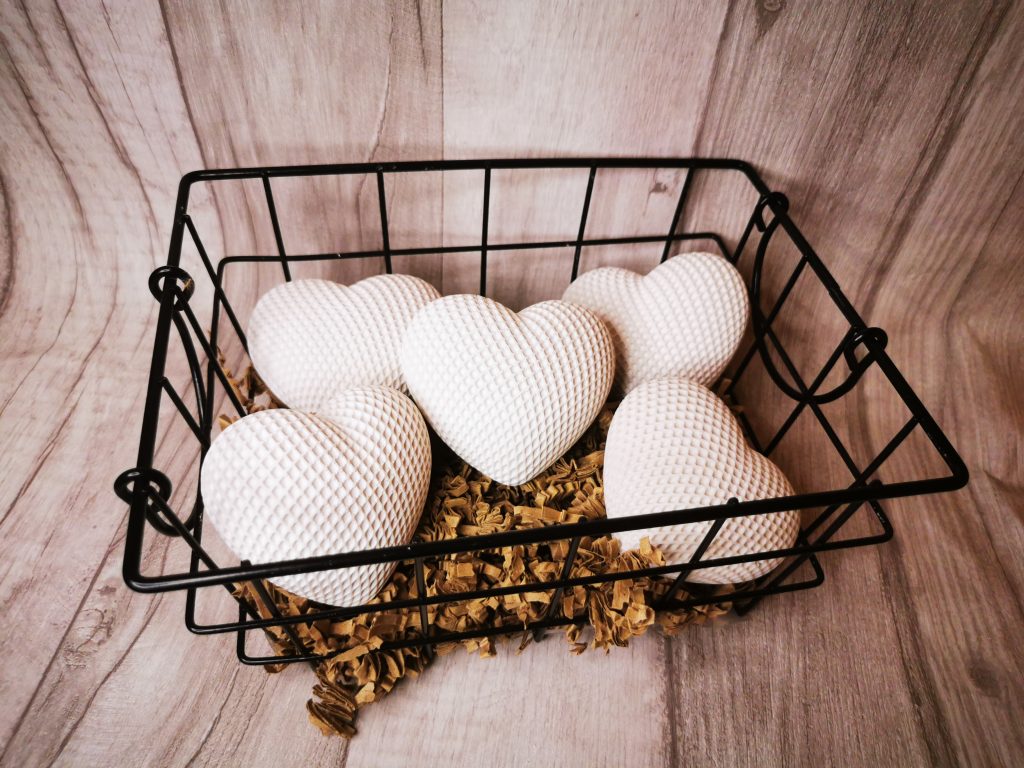 Weiße Herzen in einem Drahtkorb